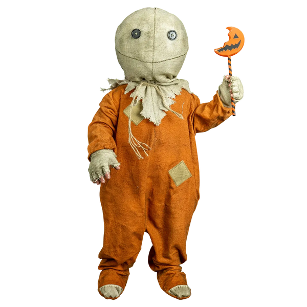 A child's Halloween costume featuring an orange jumpsuit with beige patches and a stitched face, holding a jack-o'-lantern wand, isolated on a white background.