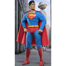 Superman action figure wearing the classic blue and red costume with a red cape, yellow belt, and red boots, posed against a city street backdrop with a globe building in the background.