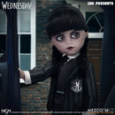 Wednesday Doll in a dark outfit with a logo, standing next to a car, with 'LDD Presents' and 'MEZCO TOYZ' branding.