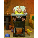 NECA Dinosaurs Ultimate Baby Sinclair 7-Inch Scale Action Figure, unpackaged sitting in baby chair with unicorn crown on top of his head
