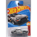 Hot Wheels '82 Toyota Supra die-cast toy car in its original blister card packaging, featuring a silver car with black and orange decals on a blue and red backing card.