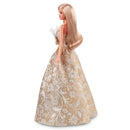 Barbie doll in a gold and white floral dress on a white background
