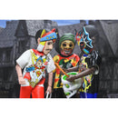 Three action figures with colorful outfits and masks against a dark, gothic-style building background.