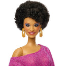 Barbie doll with curly hair, blue eyes, and a pink outfit on a white background