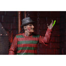 Freddy Action figure in a red and green striped sweater with a hat, holding a green glove against a dark background.
