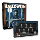 Halloween tabletop game box shown behind a boxed set of 7 miniature character figures. The front box features a dark illustrated cover with the title HALLOWEEN and a moonlit scene.