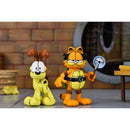 Garfield and Odie cartoon character figurines in a room with a brick wall and table in the background.