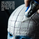Person applying glue to a mask with text instructions on a dark background