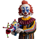 Colorful clown figurine holding a toy gun on a white background