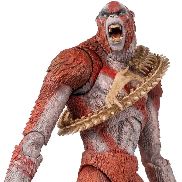 Action figure of Skar King with red and gray skin, wearing skeleton-like shoulder belt on a white background