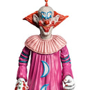 Colorful clown figurine with pink outfit and red hair on a white background