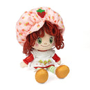Plush doll with red hair, strawberry-themed outfit, and hat on a white background