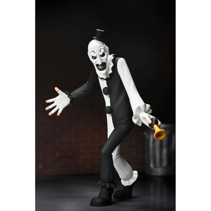 Terrifier Art the Clown Toony Terrors 6-Inch Scale Action Figure holding small horn in hand with brick wall and metal trash can in background