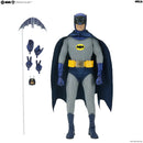 Batman action figure with cape, shown standing on a white background with interchangeable hands and a bat-shaped accessory. Visible branding includes Batman and MECA.