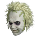 A latex mask of Beetlejuice with messy pale yellow hair, green mold-like growth details, and dark purple eye makeup, shown against a plain white background.