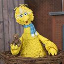 big bird in nest and holding a teddy bear