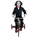 Action figure in a suit riding a tricycle on a white background
