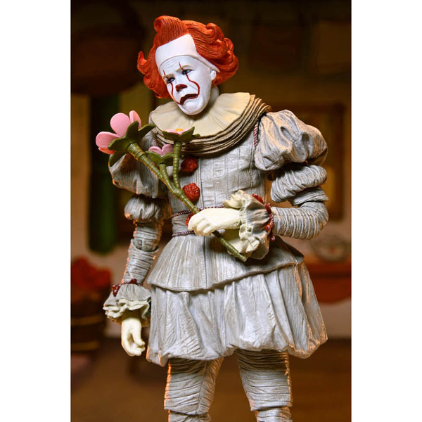 Pennywise the Clown figurine with red hair and white face holding flowers against a blurred background