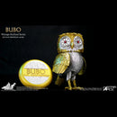 A vintage-style owl collectible figure labeled BUBO, shown beside a round matching accessory on a black background. The owl has metallic gold and silver feathers, large white eyes with red star details, and gold feet.