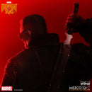 Marvel's Midnight Suns One:12 scale collectible figure of a character from behind, wearing a dark textured jacket and holding a knife, under dramatic red lighting with official Marvel and Mezco Toyz branding.