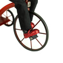 Close-up of a red glittery shoe pedaling a unicycle on a white background