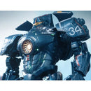 A close-up of a detailed sci-fi mecha robot in dark metallic blue-gray armor with glowing green lights, a circular orange chest emblem, and the number 34 on the shoulder, set against a pale blue background.