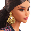 Close-up of a doll with gold earrings and traditional attire