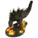 Godzilla monster like figurine with flames on a white background