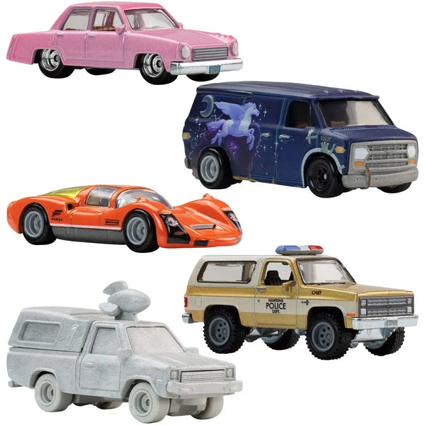 Five toy cars and trucks shown on a plain white background: a pink vintage sedan, a blue van with a unicorn graphic, an orange sports car, a beige and blue police SUV, and a light gray pickup truck.