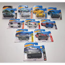 A collection of ten Hot Wheels toy cars in their original blister packaging, arranged on a light gray surface.