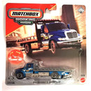 Matchbox Working Rigs die-cast toy truck in its original blister card packaging. The toy is a blue International diamond truck with a flatbed, featuring a graphic of the truck on the red and white header card.