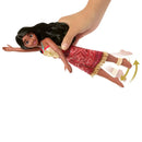 Toy doll with a red dress being held by a hand on a white background
