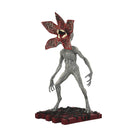 Statue of a creature with a red flower-like head on a white background