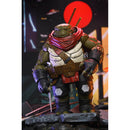 Action figure of a turtle character Odyn with a red scarf and armor, standing on a platform with a colorful background.