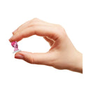 Hand holding a small pink figurine against a white background