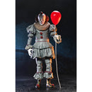 Action figure of a clown holding a red balloon against a dark background