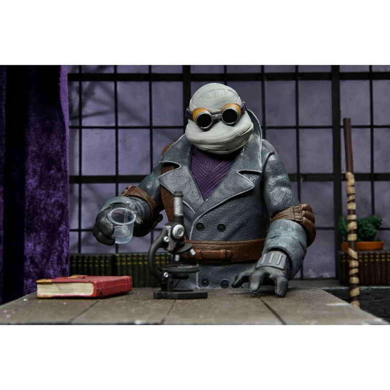 NECA Universal Monsters x Teenage Mutant Ninja Turtles Ultimate Donatello as The Invisible Man 7″ Scale Action Figure, at table with microscope, book, and  glass accessories.
